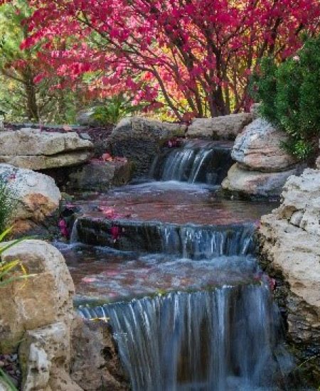 Peaceful garden waterfall with colorful foliage